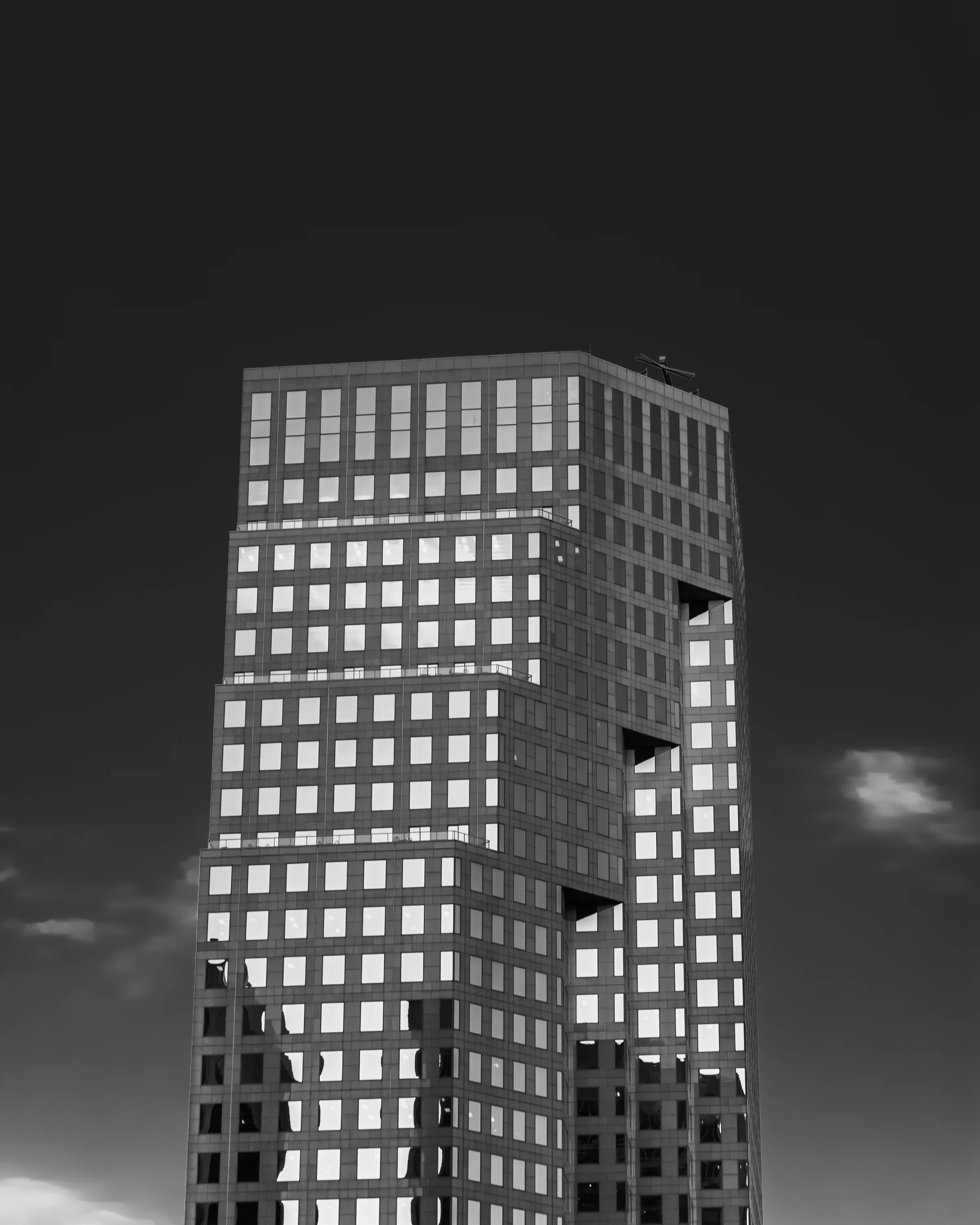 Black-and-white architectural study of a high-rise against a dark sky